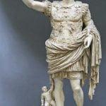 Why does the statue of Emperor Augustus have a baby attached to one leg?